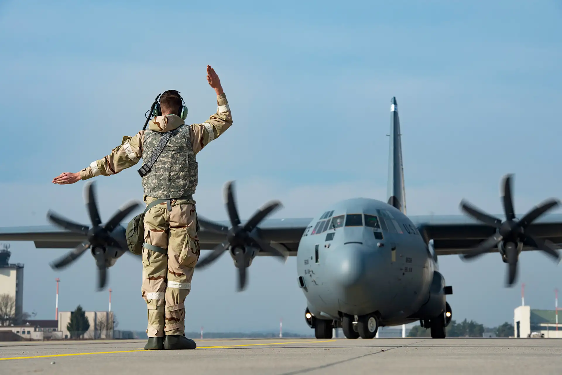 Crew chief marshaling a C-130J Super Hercules for launch